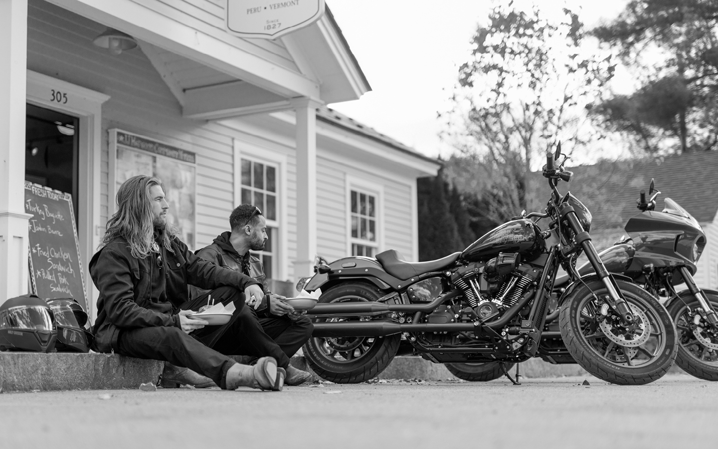 Mike Clark and AJ Garron sit on curb as they eat