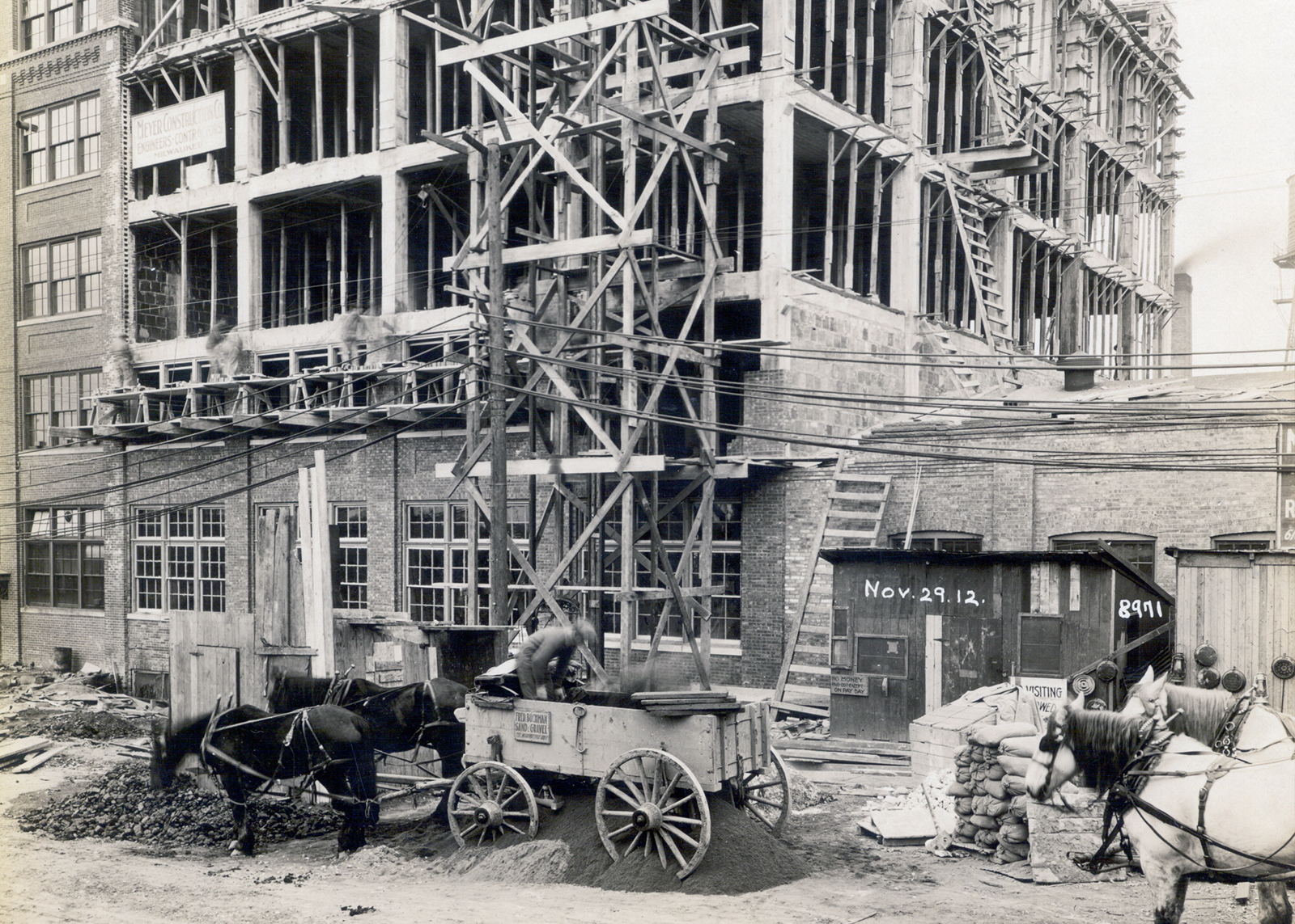 Horses in front of a warehouse under construction