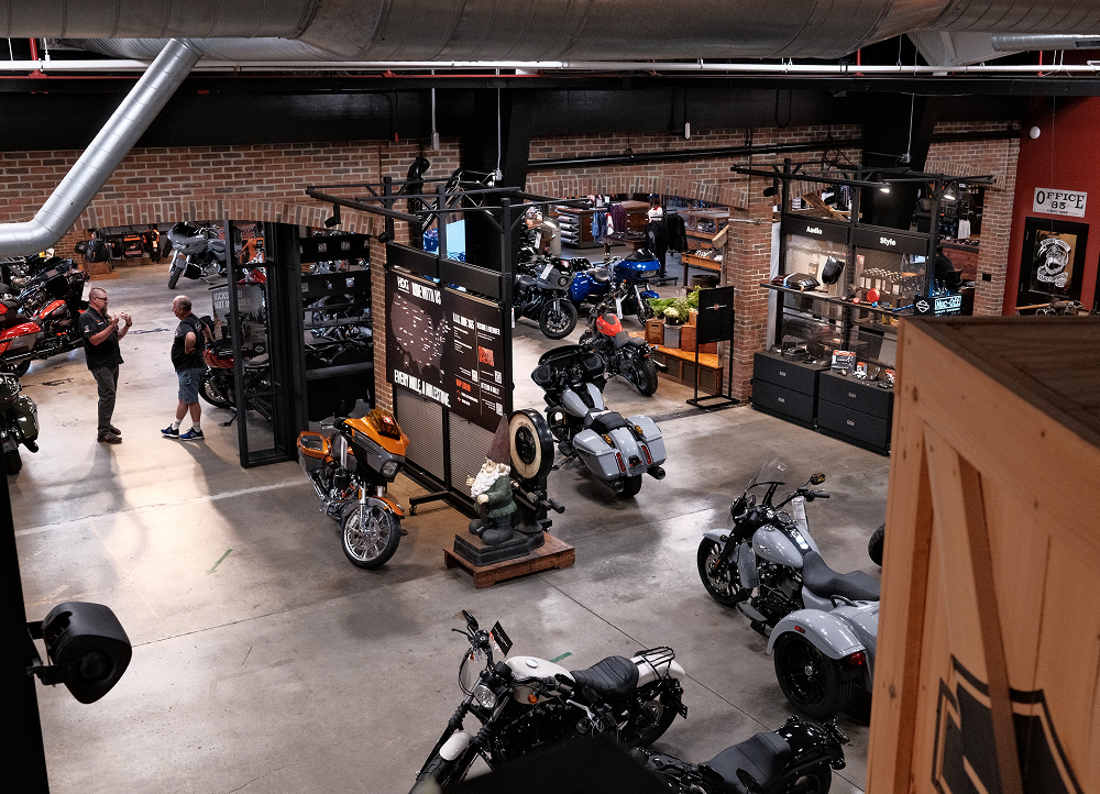 Wide view of Harley-Davidson showroom with motorcycles, merchandise displays, and customers browsing
