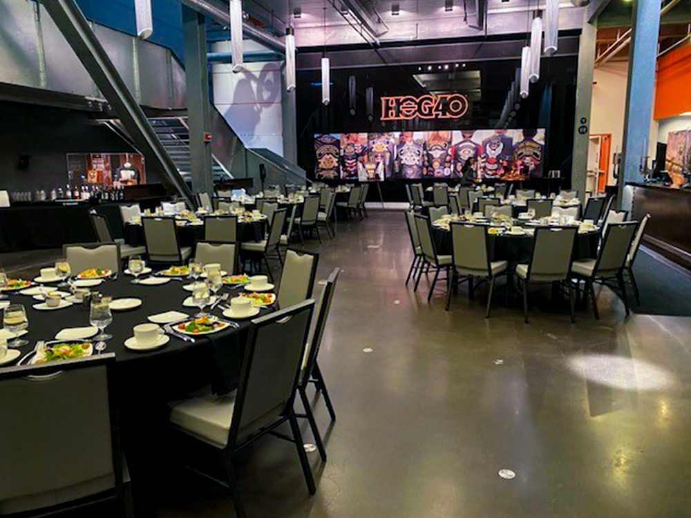 Banquet hall with round tables, stage screen, and dining setup
