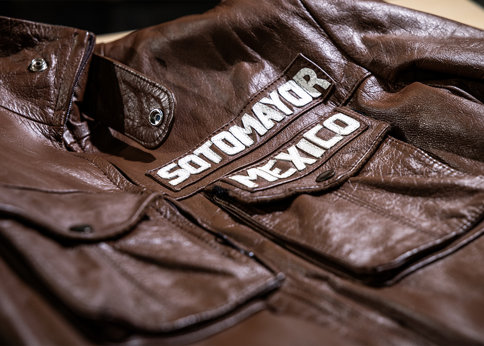 Sotomayor’s brown leather riding suit with white lettering above the chest pocket on display at the Harley-Davidson Museum Archives.