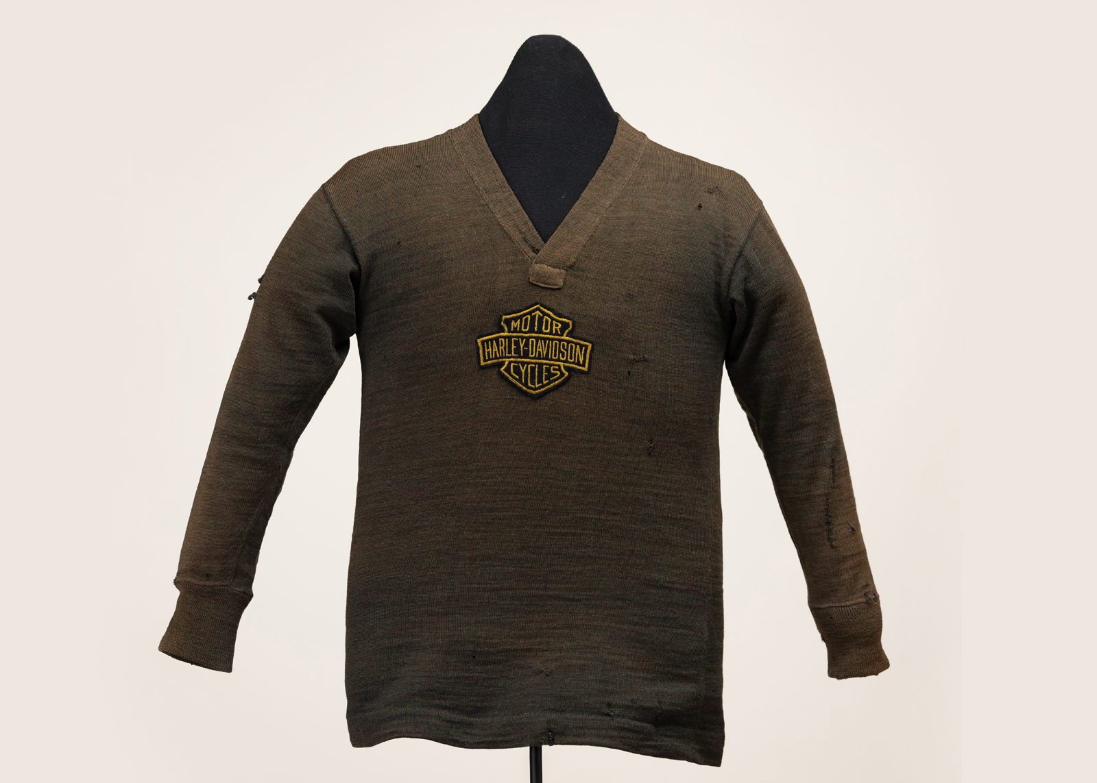 A vintage brown v-neck sweater on a mannequin