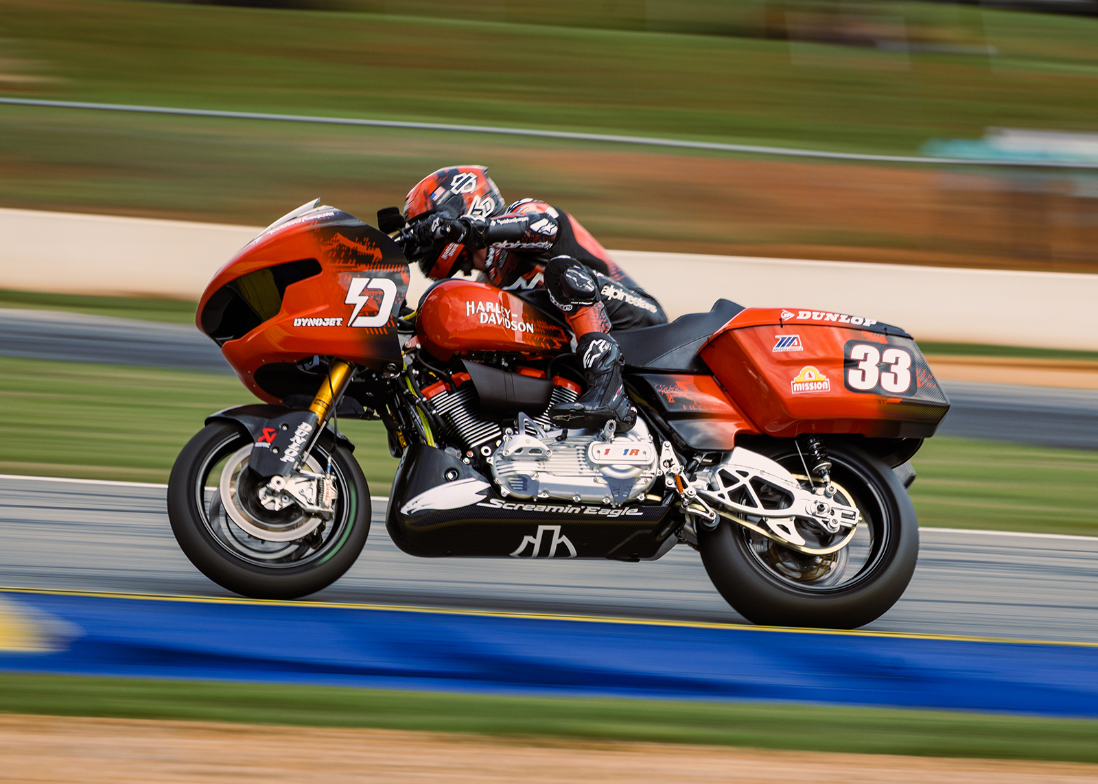 A closeup of Bradley Smith riding his bright orange bagger around a curve on the track.
