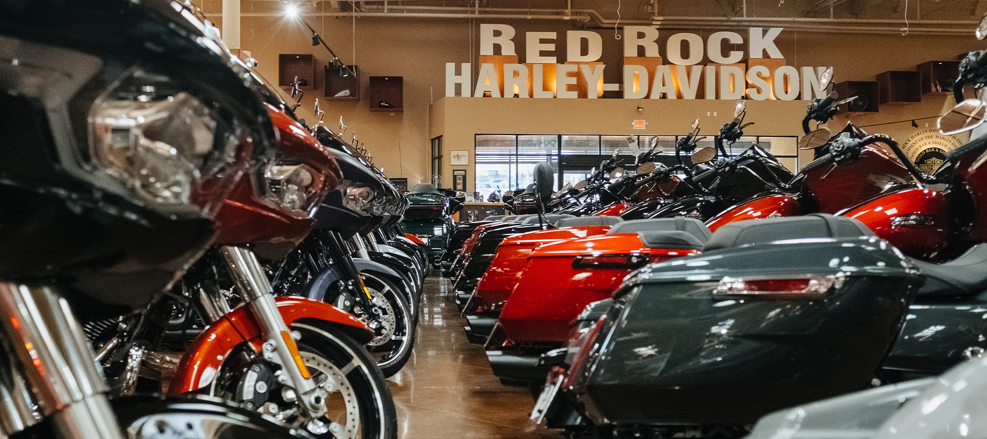 Motorcycles lined up on the showroom floor of Red Rock Harley-Davidson dealership.
