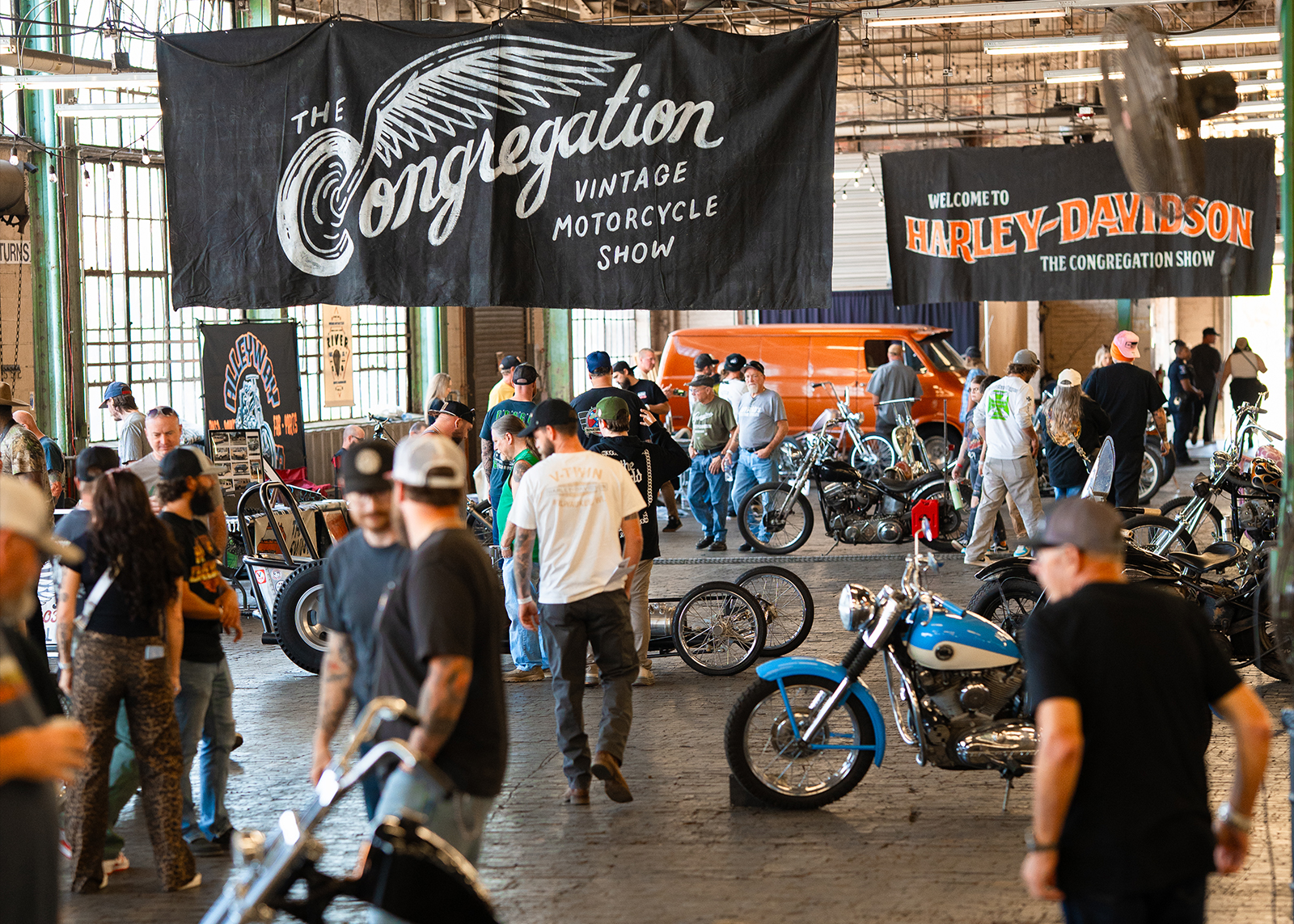 Crowds explore custom bikes and vendor booths at The Congregation Vintage Motorcycle Show indoors.
