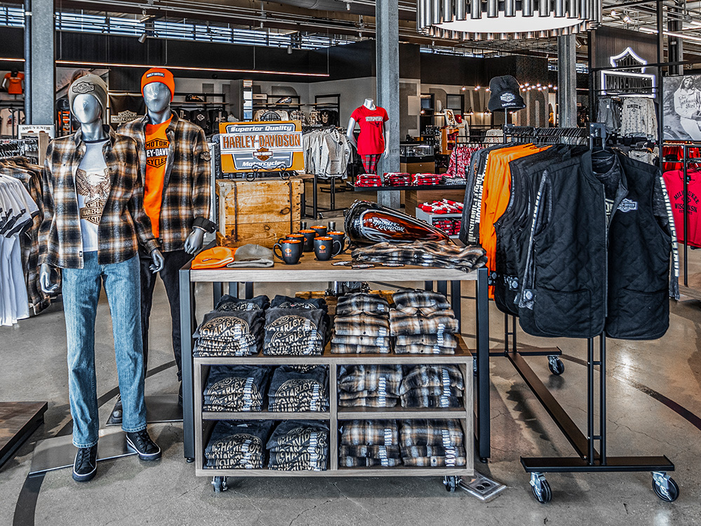 Retail display with mannequins, folded shirts, and jackets on racks