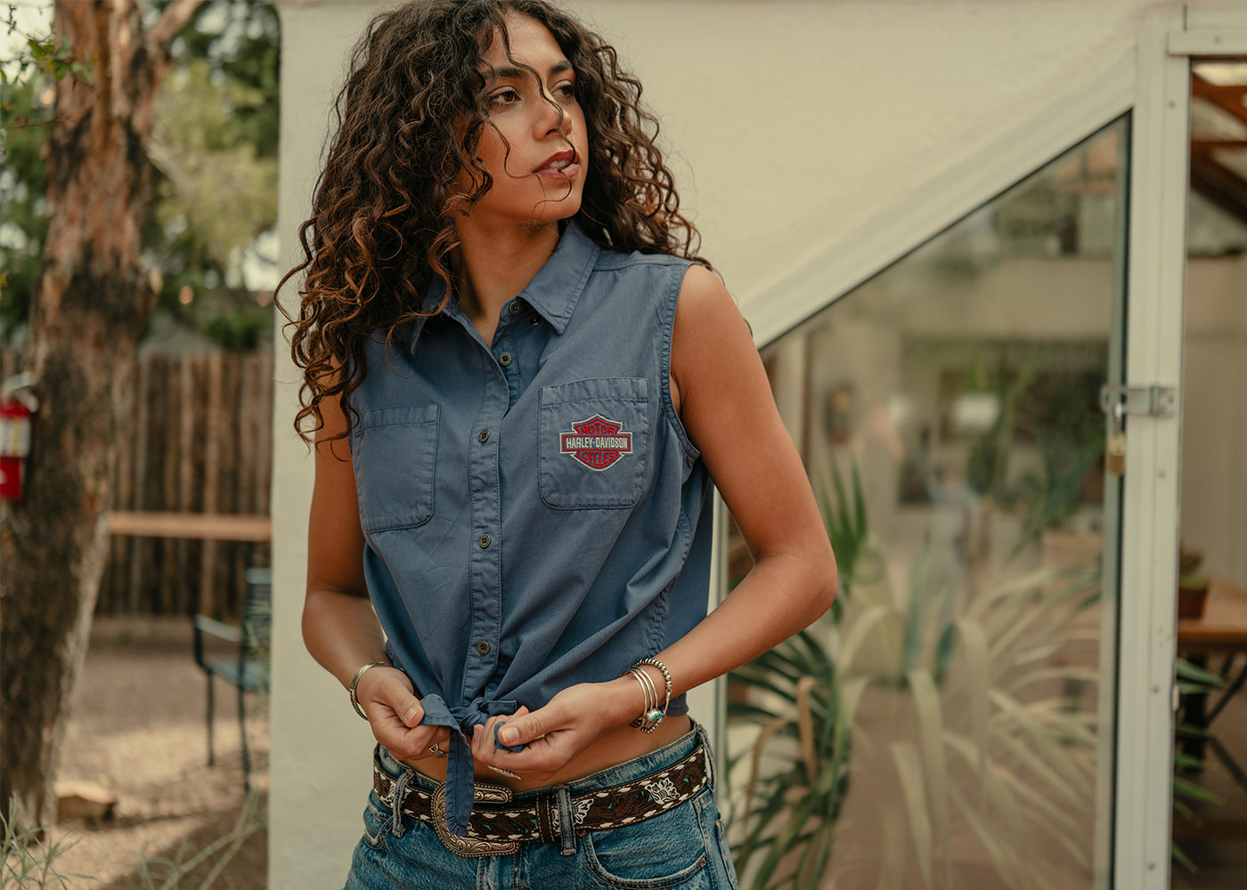 Woman in blue denim sleeveless H-D tie-front top