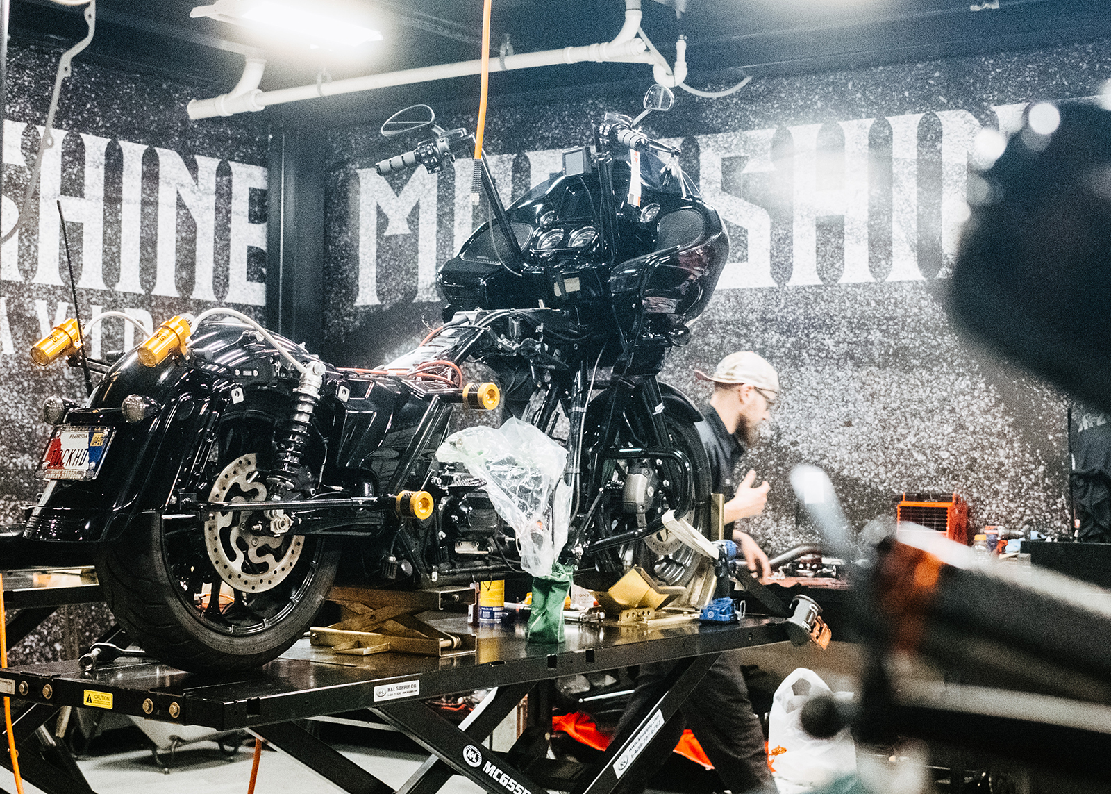 A mechanic works on performance upgrades on a Harley-Davidson in the garage at Moonshine Harley-Davidson.