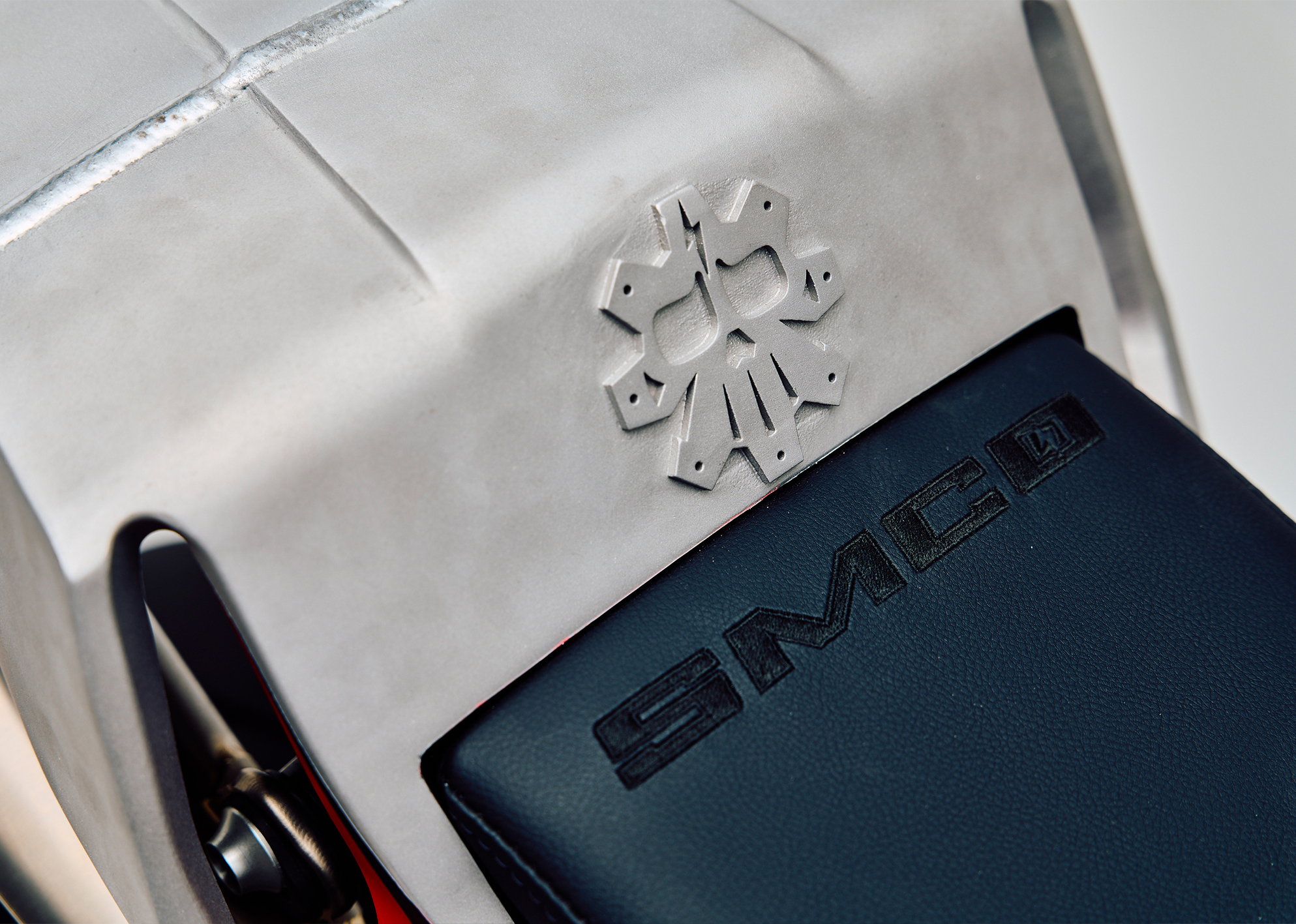 Close-up of the custom Pan America ST’s seat with SMCO logo embossed in leather and engraved metal skull emblem.
