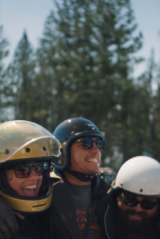 Drei lachende Fahrer mit Helmen