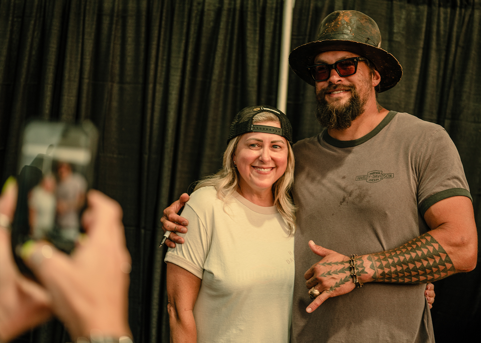 Jason Momoa poses for a photo with a fan