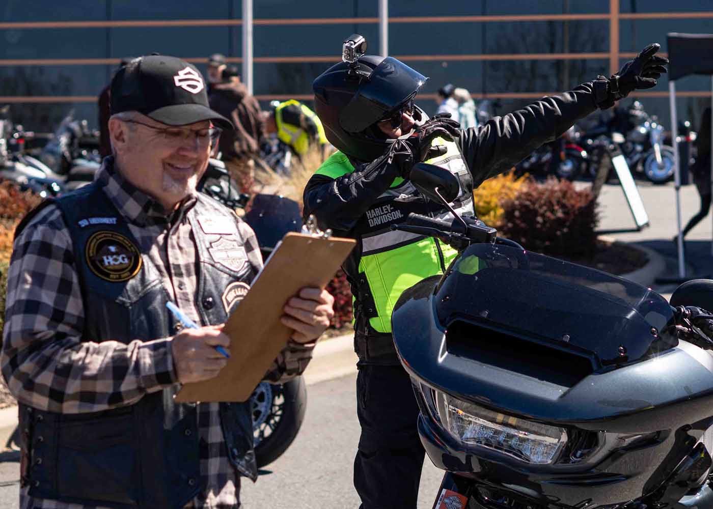 H-D team member talking to rider on demo bike