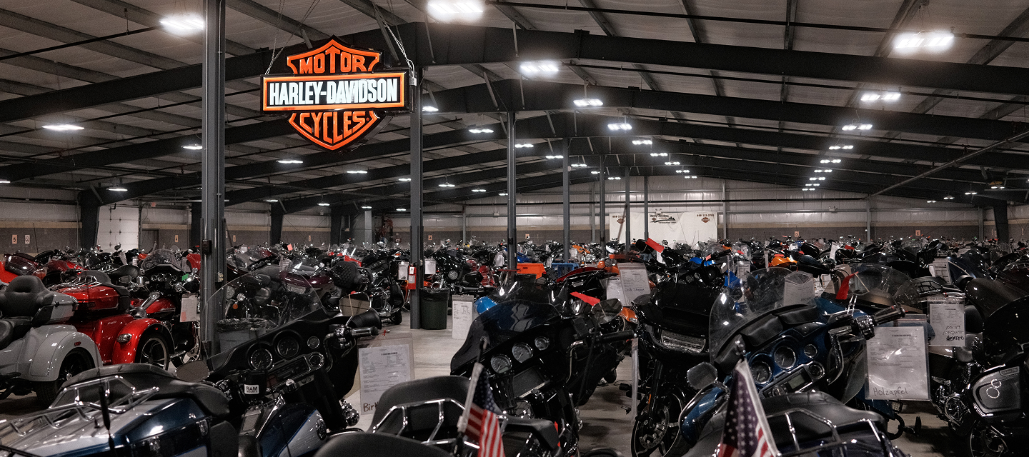 The expansive indoor storage area at Harley-Davidson of Madison, with countless motorcycles beneath a large brand logo sign