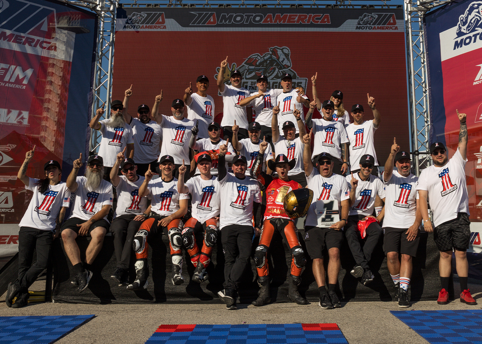 Kyle Wyman surrounded by the Harley-Davidson Factory Racing team celebrates victory on the podium at Circuit of the Americas.