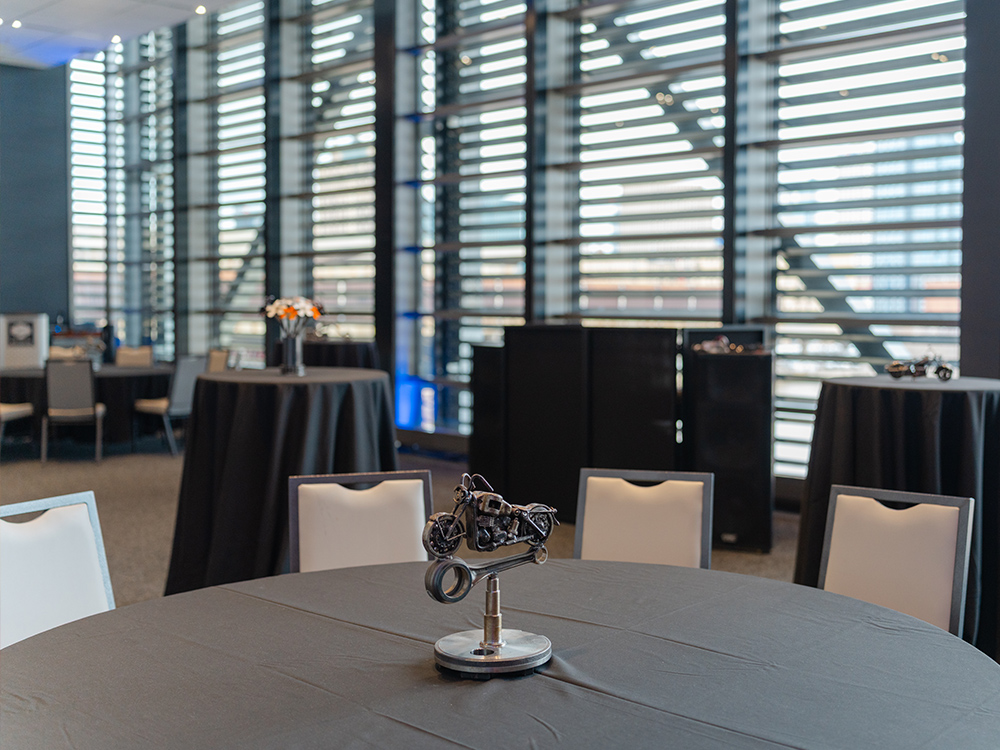 Round table with black linen and miniature motorcycle centerpiece in event space