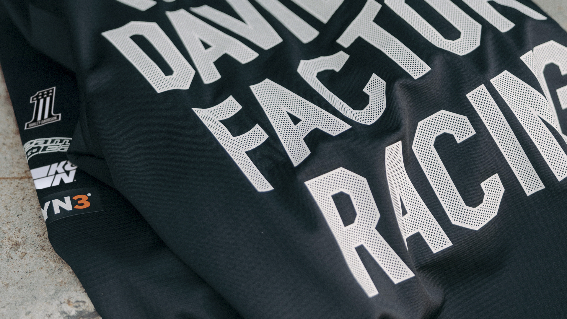man and woman wearing factory racing clothing