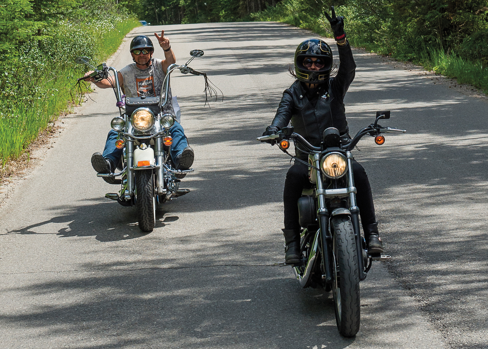 Man and woman on their bikes giving the peace sign
