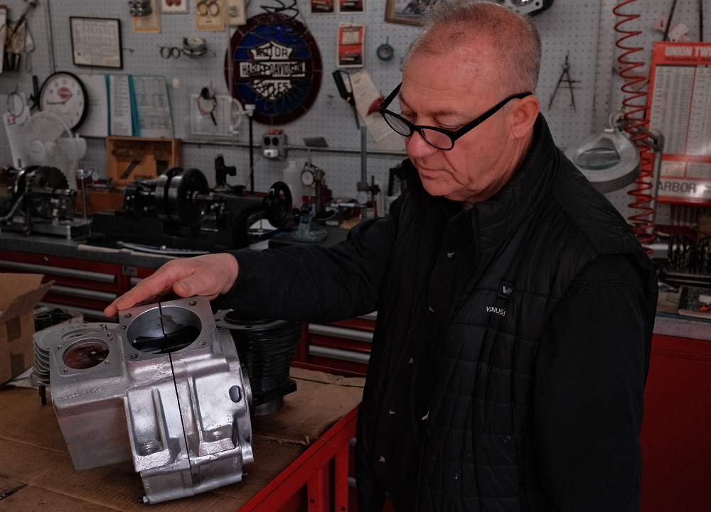 Richie Pilavin inspects a machined engine case on workbench inside his service shop with tools and equipment