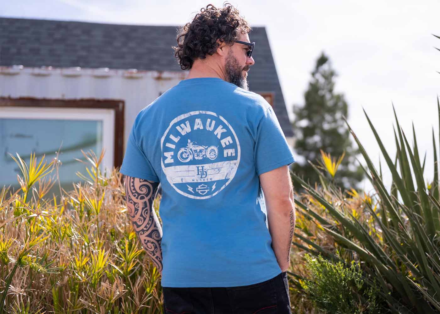 Man with beard wearing blue tshirt facing away from camera
