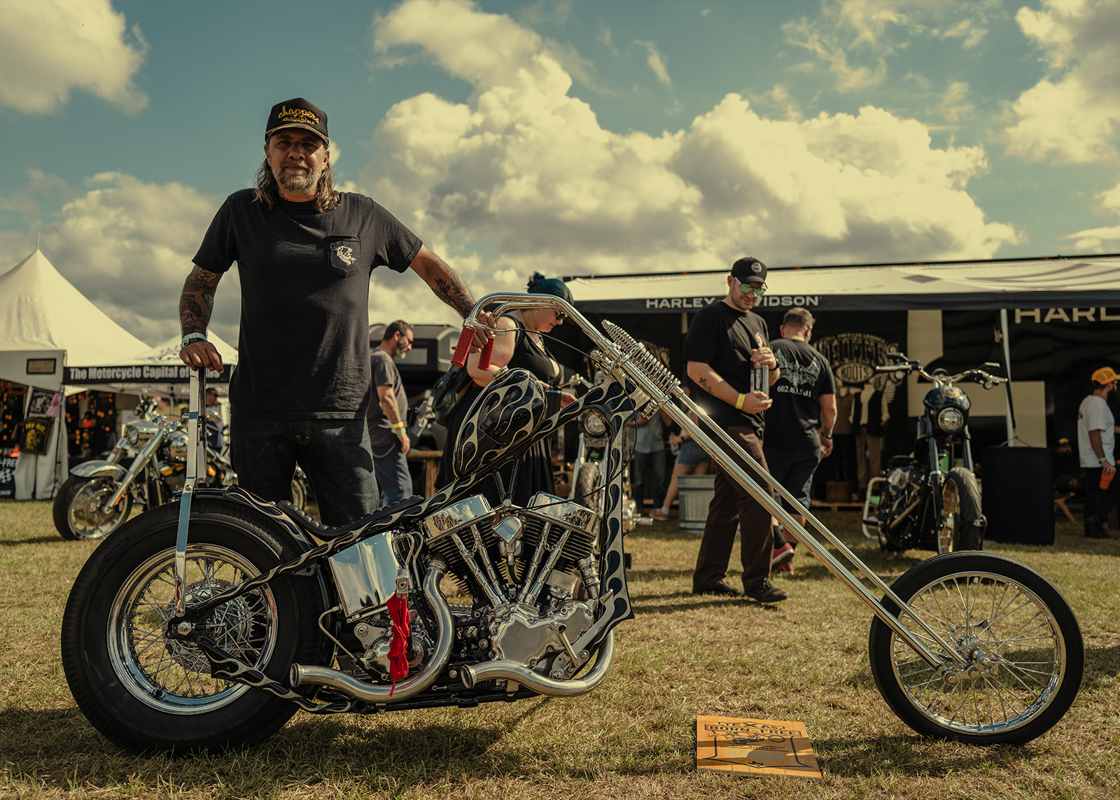 Scott Hoepker stands beside his custom 1960 Harley-Davidson Panhead at the Born Free Texas rally under sunny skies.