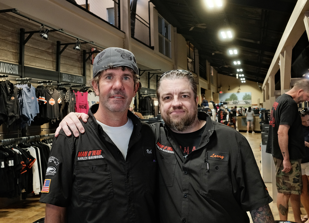 Two Man O’ War Harley-Davidson employees pose smiling with arms around each others shoulders