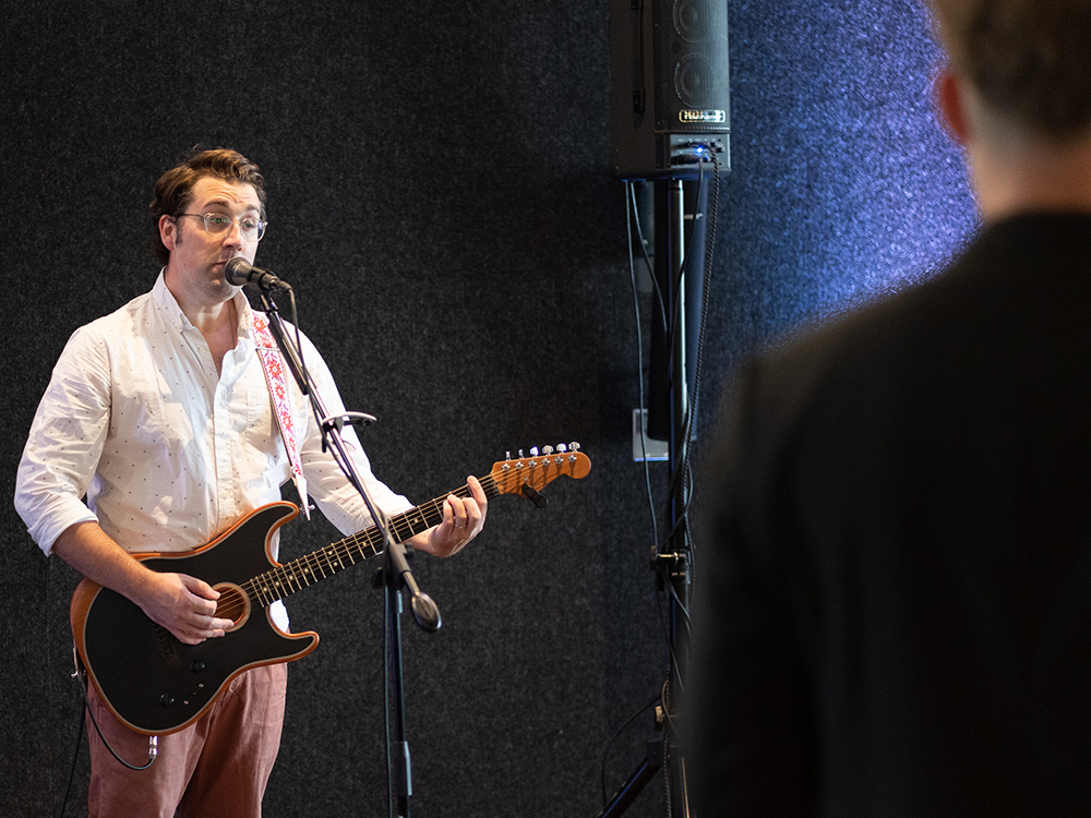 Musician playing electric guitar and singing on stage