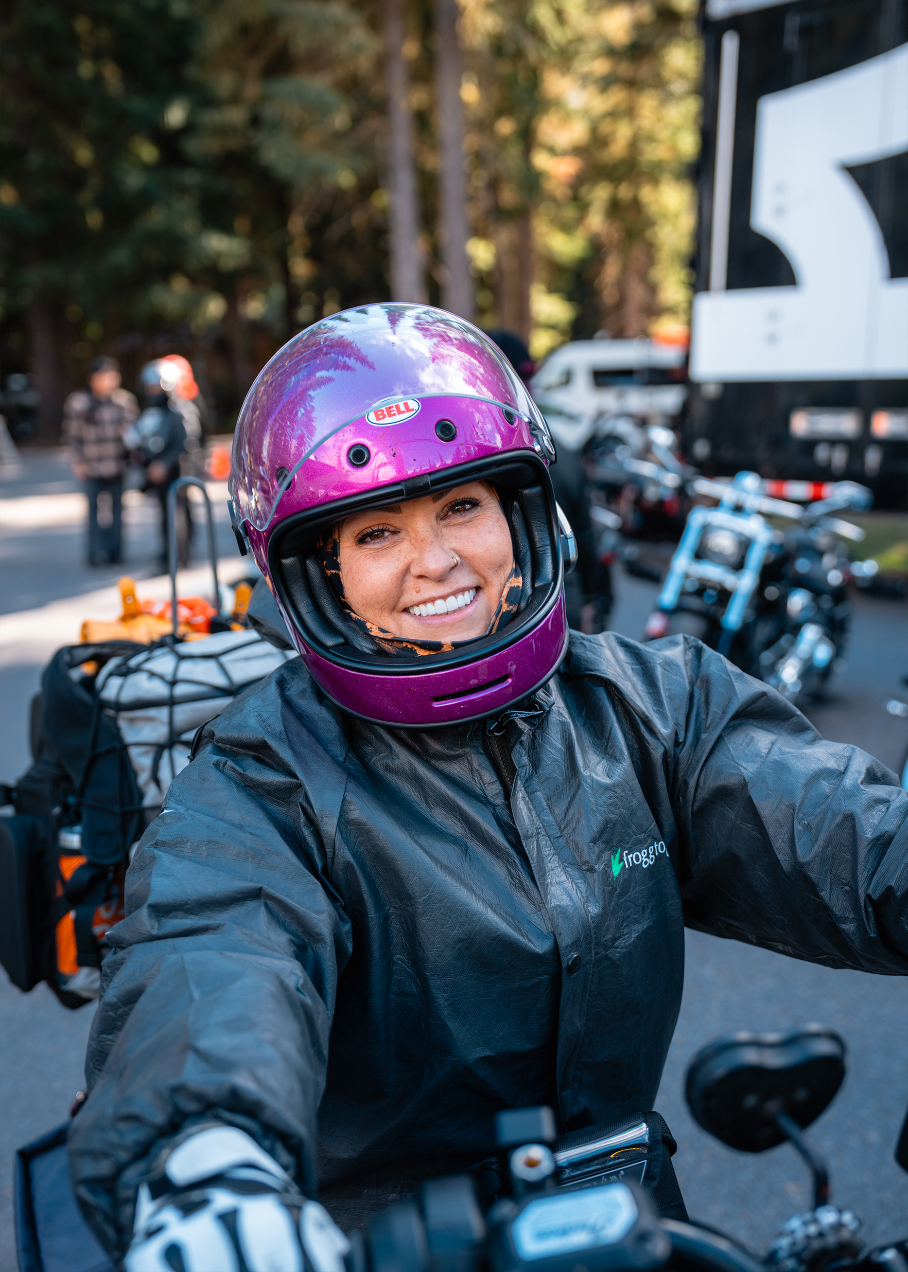 A tattoo artist inks a detailed floral design on a person’s arm inside a cozy, well-lit trailer.