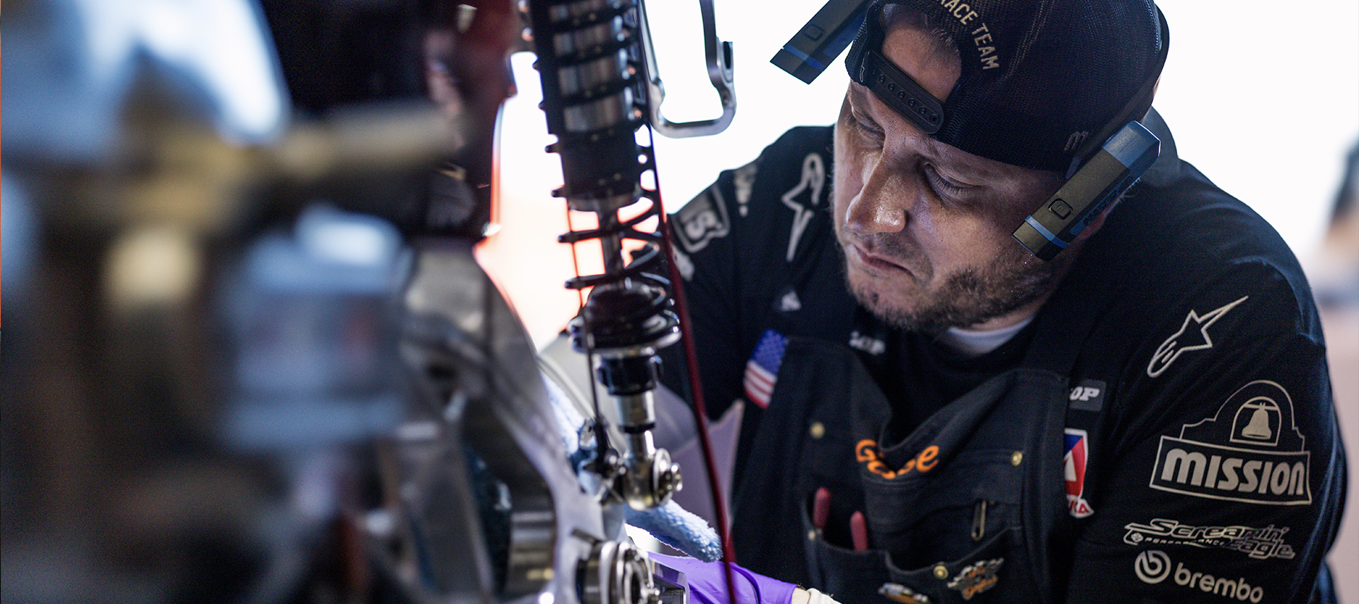 Harley-Davidson Factory Racing Mechanic Kevin “Goose” Gaikowski works on the rear suspension of a race bike.