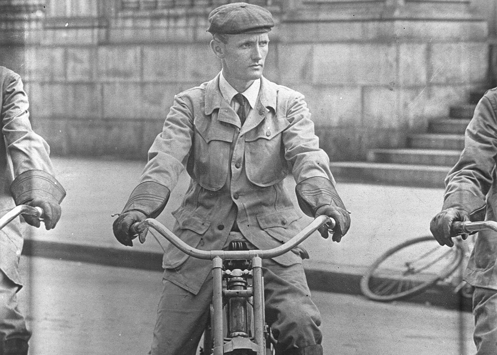 black and white photo of a man sitting on a motorcycle 