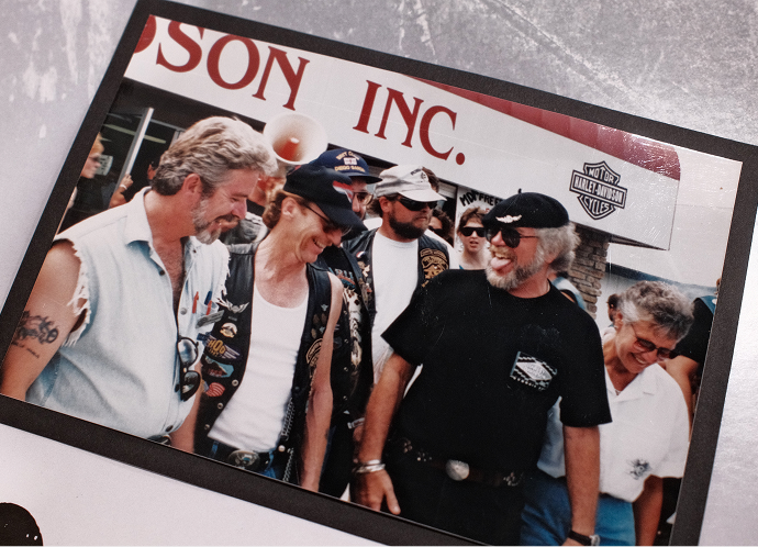 A vintage photo of Virgil Schulenberg with Willie G. Davidson and others at an event at Harley-Davidson of Madison