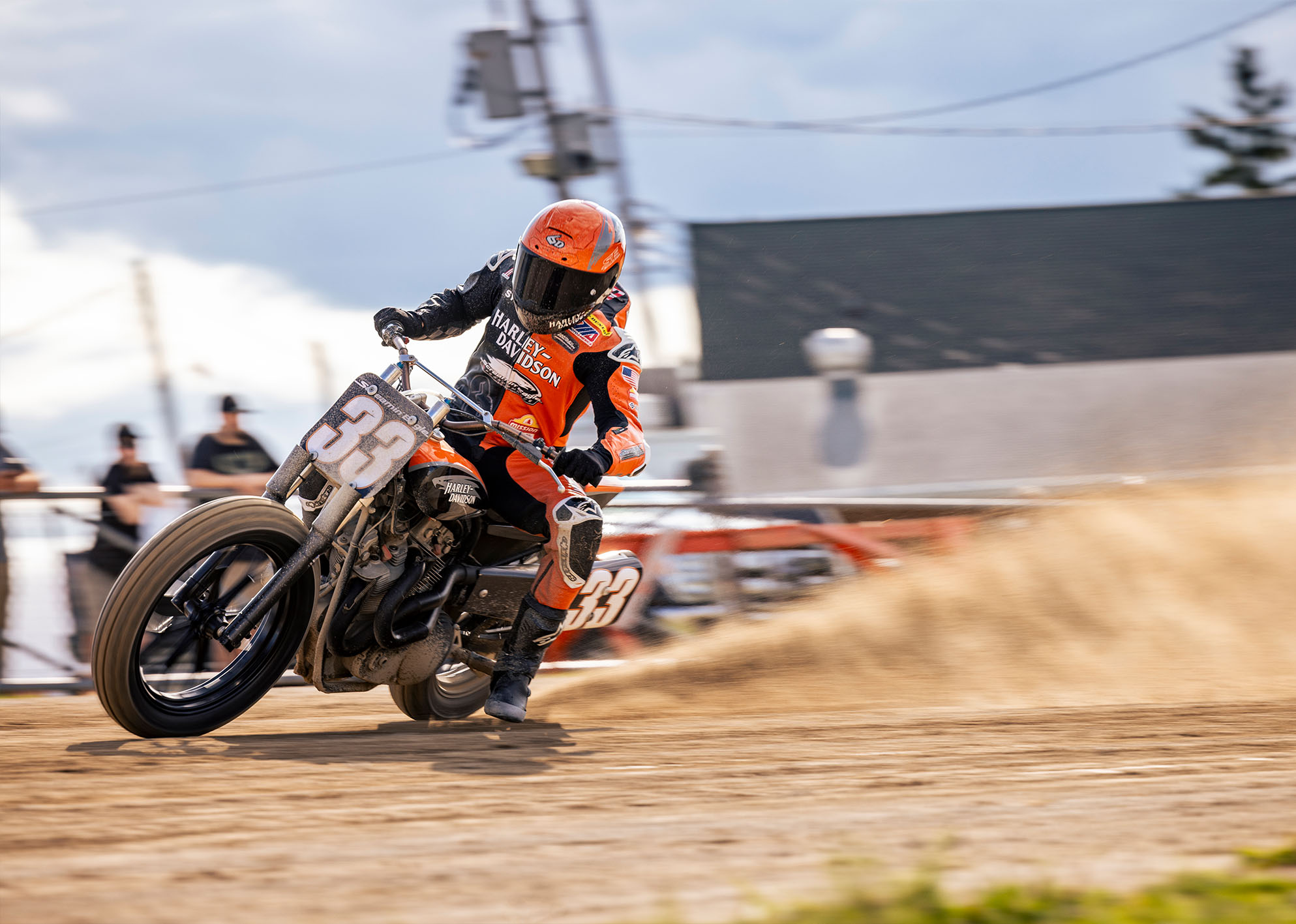 Kyle Wyman rides sideways on a dirt flat track with a rooster tail of dirt flying behind