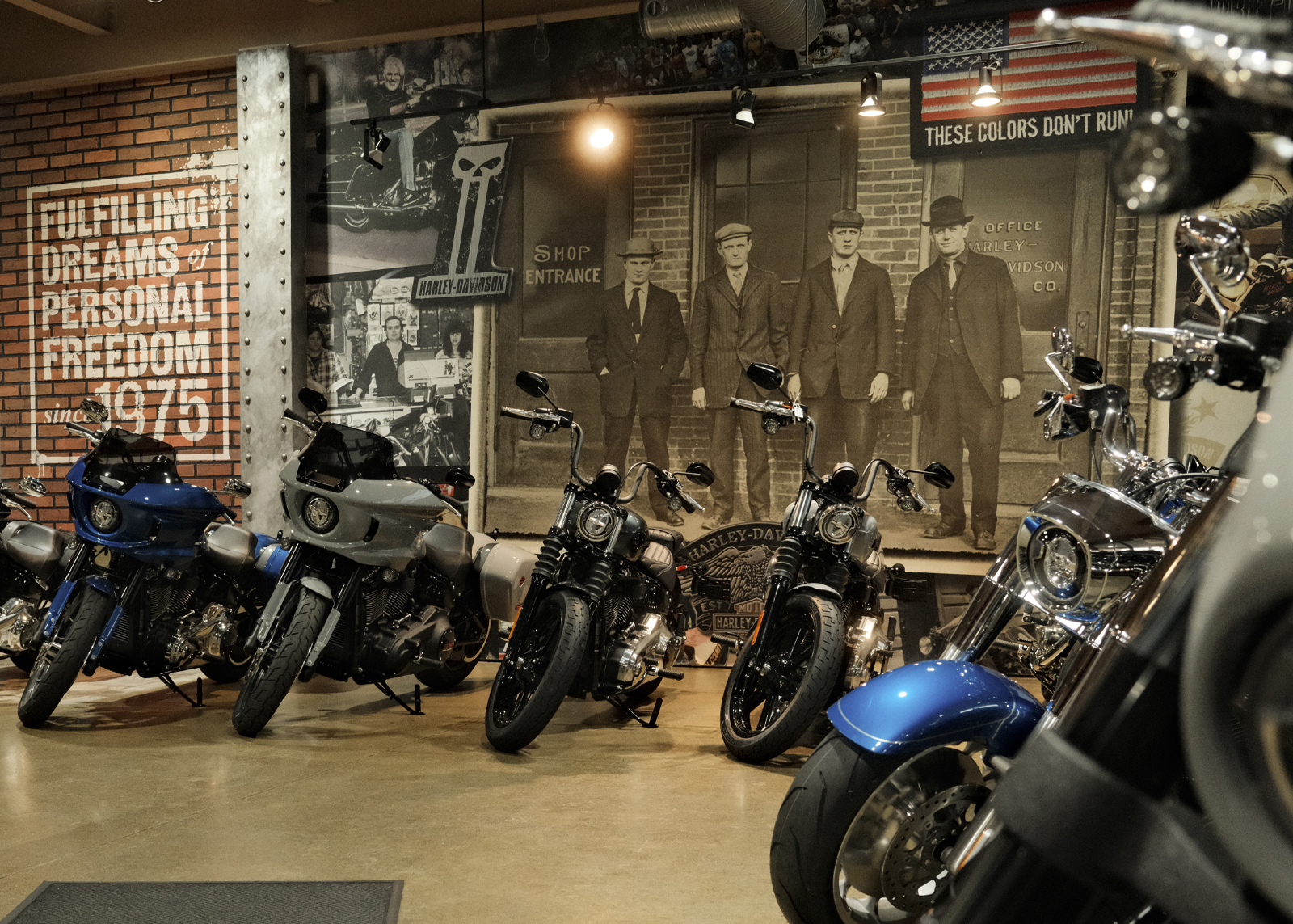 Display of motorcycles inside the Bergen Harley-Davidson showroom with vintage photo wall backdrop.