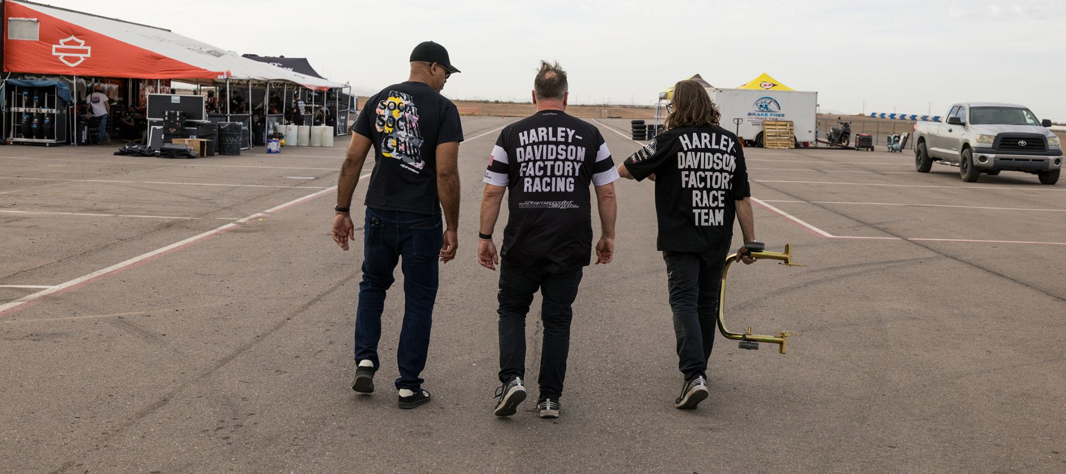 The author and two Harley-Davidson Racing crew members in mid-conversation walk away from the camera