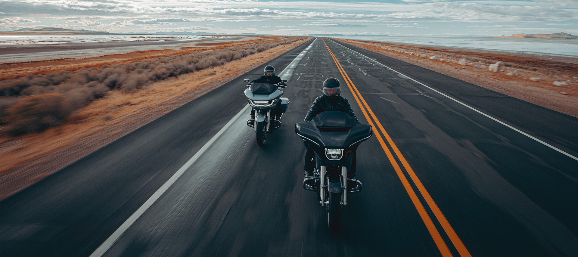 Motorcycle riders on touring bikes ride through countryside