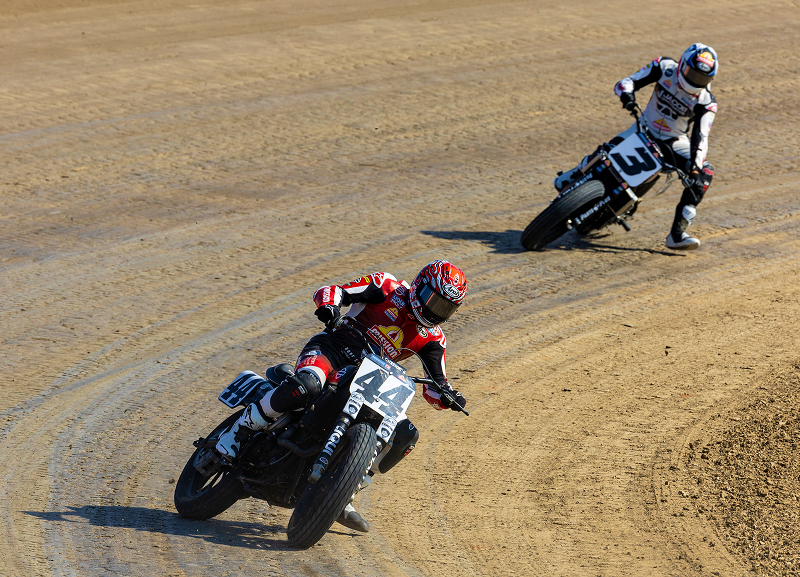 Brandon Robinson rides motorcycle #44 through a sweeping dirt-track corner with a competitor trailing behind