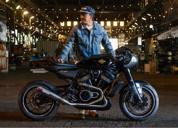 Person standing beside the Harley-Davidson cafe racer concept RMCR motorcycle at The One Moto Show