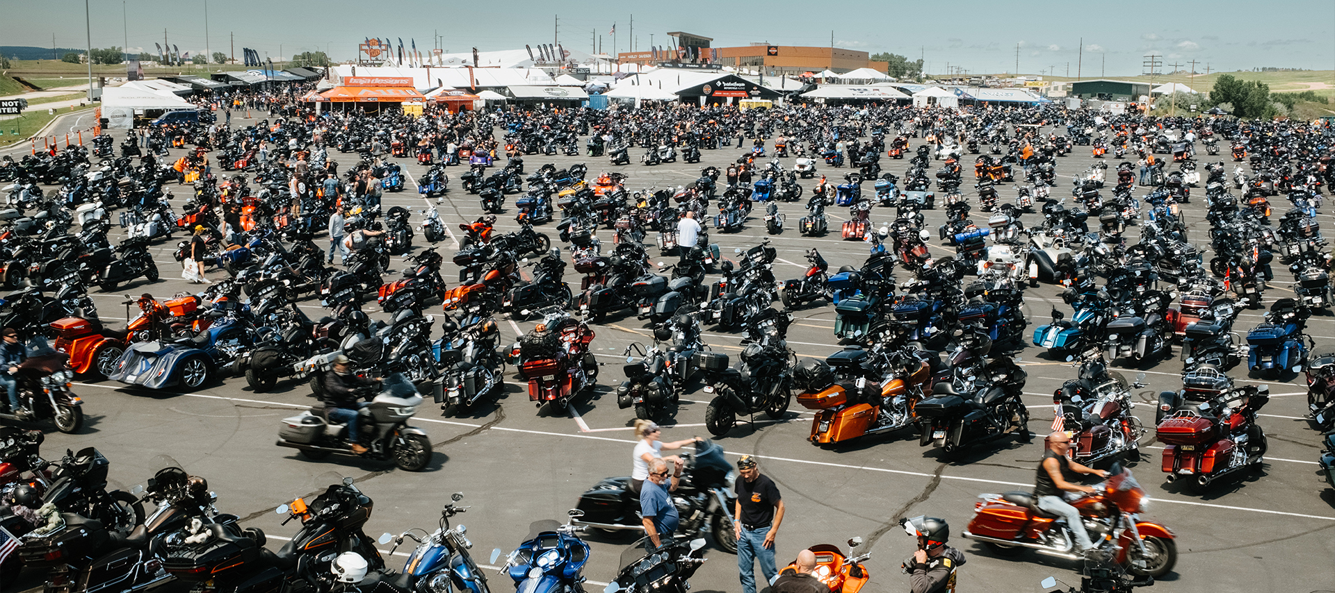 A massive lot packed with motorcycles and riders during the Sturgis Motorcycle Rally at Exit 55.