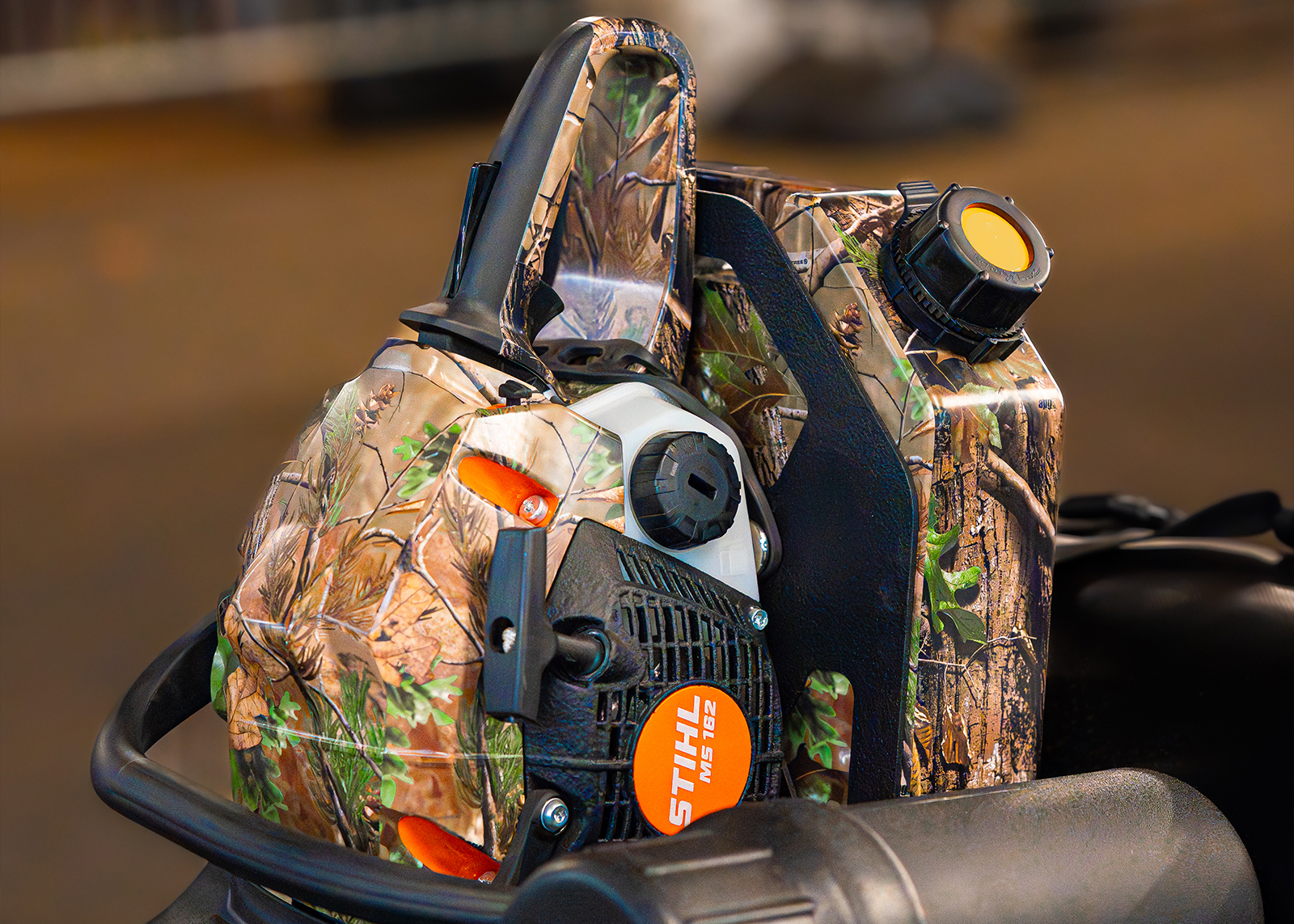 Close-up of a camo-wrapped STIHL chainsaw and fuel can mounted on the back of the Harley-Davidson x Realtree Pan America build.