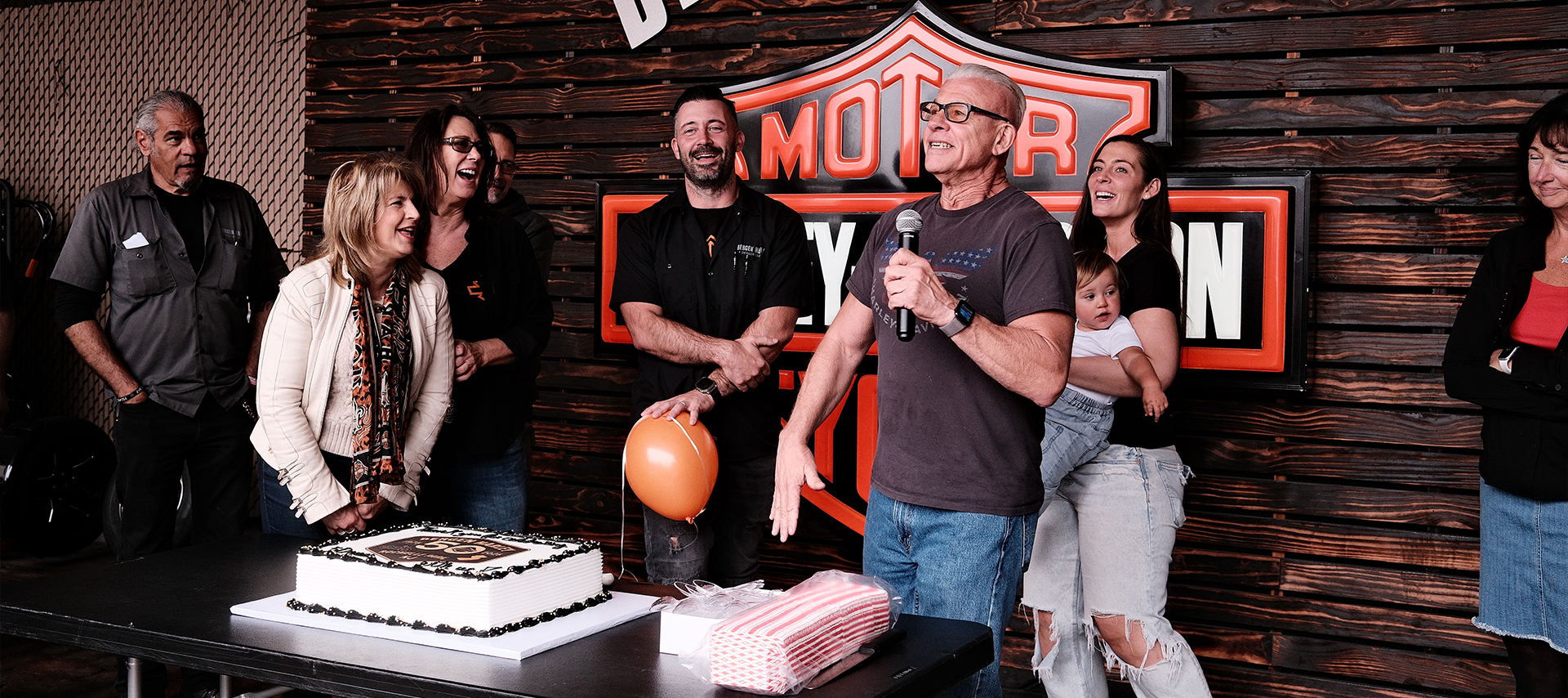 Bergen H-D’s Phil DiGennaro takes the mic during the 50 year party as friends and family smile and laugh around him.