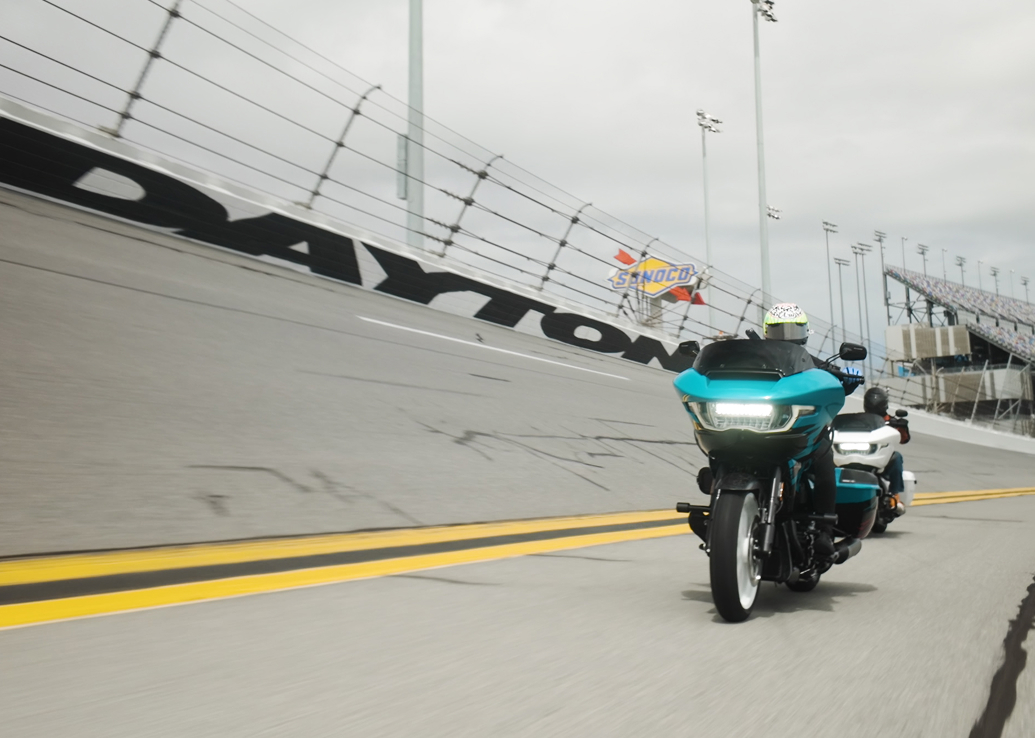 A touring motorcycle rides along the steep banks at Daytona International Speedway track during a parade lap