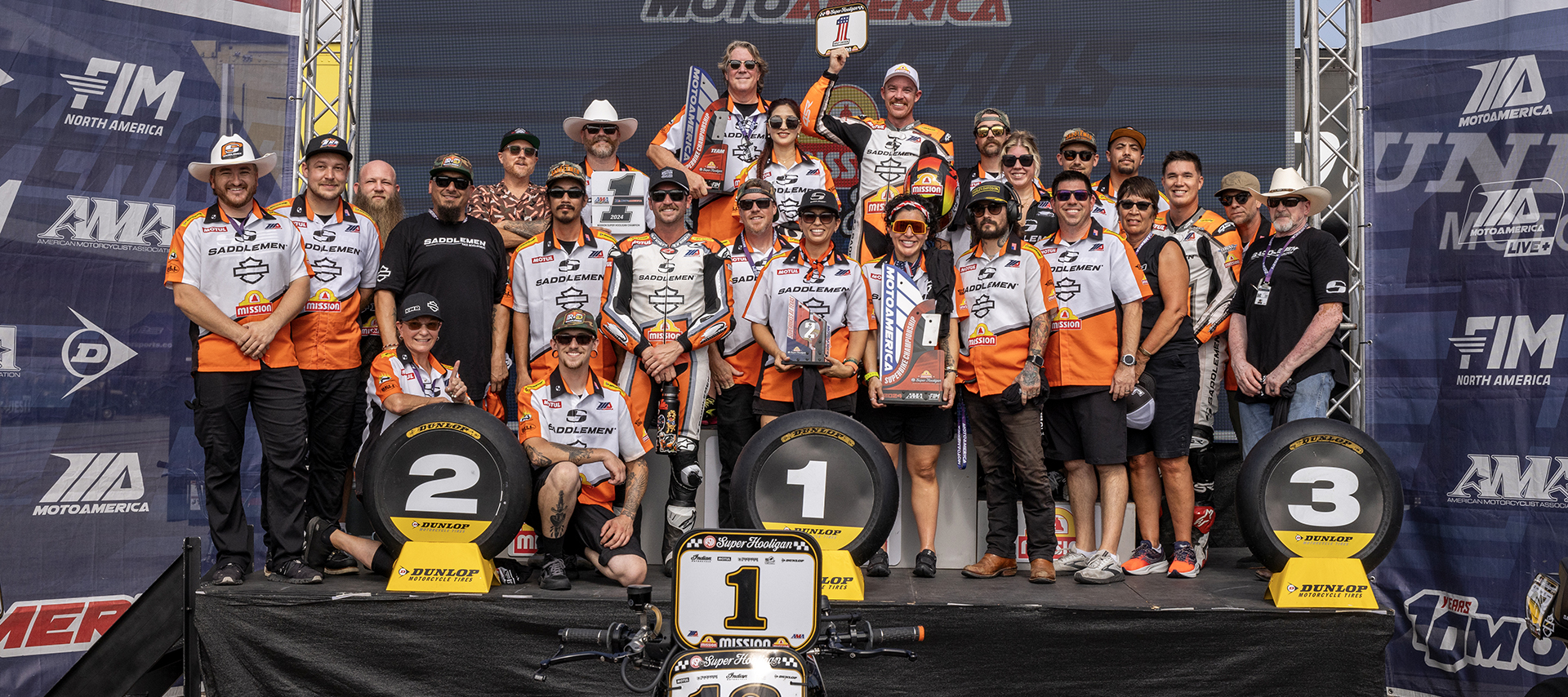 Team Saddlemen celebrates with Cory West on the podium following a win
