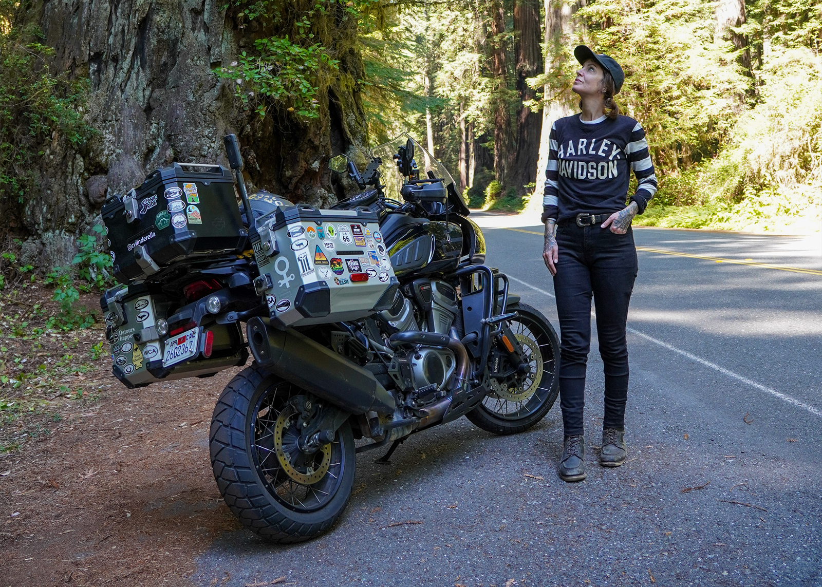 The author Sanna Boman standing next to her Harley-Davidson Pan America in Redwood National Park.