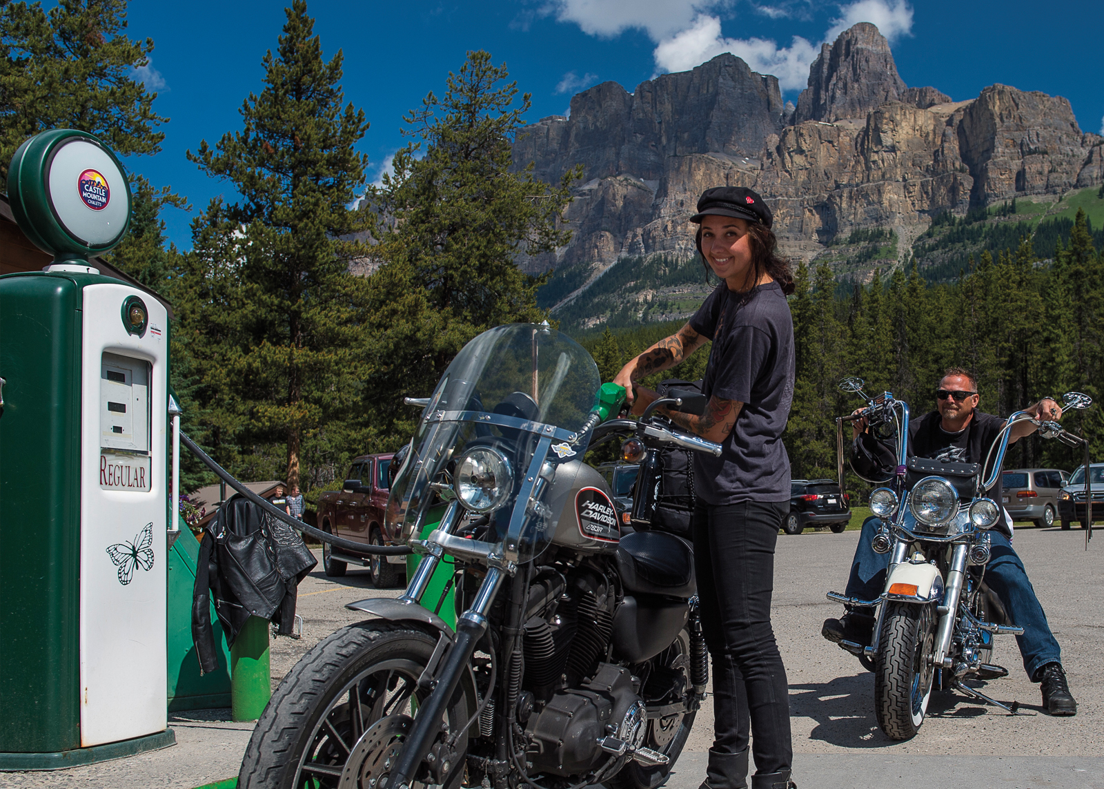 Woman filling up her bike with gas with mountains in the background
