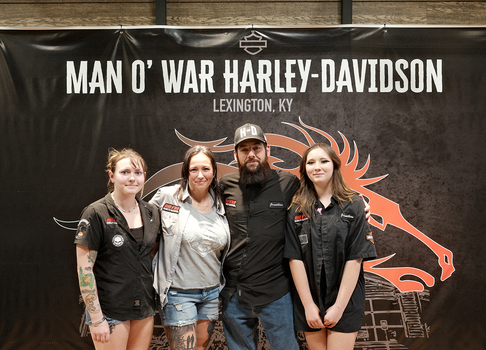 Dealership staff pose in front of a Man O’ War Harley-Davidson branded backdrop