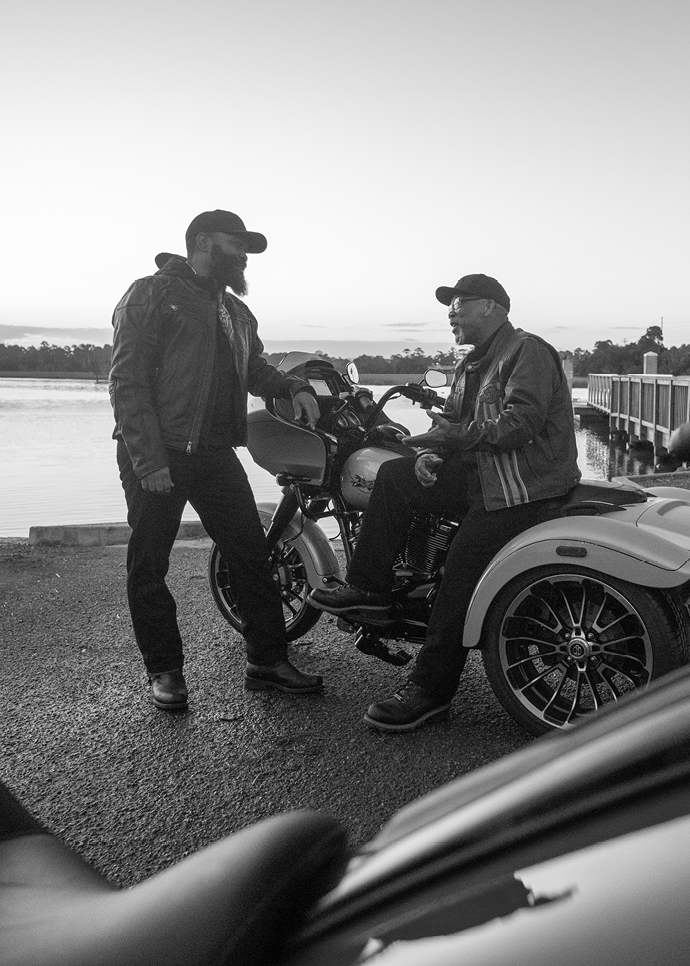 Larry Warre Sr sits on bike as his son talks with him