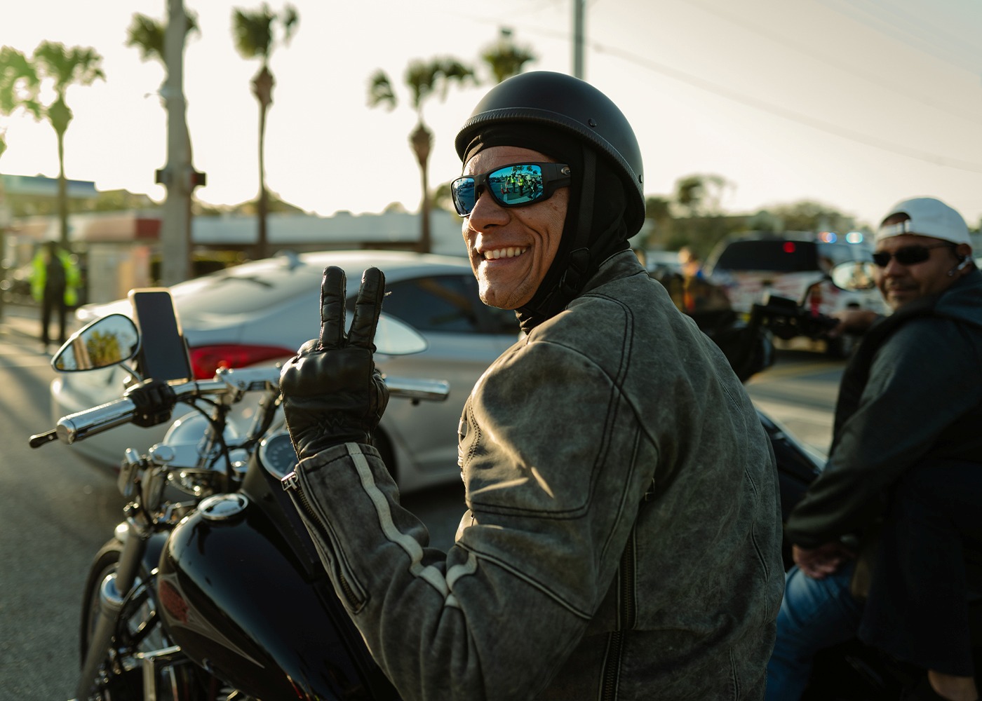 Rider smiling on his motorcycle giving a peace sign