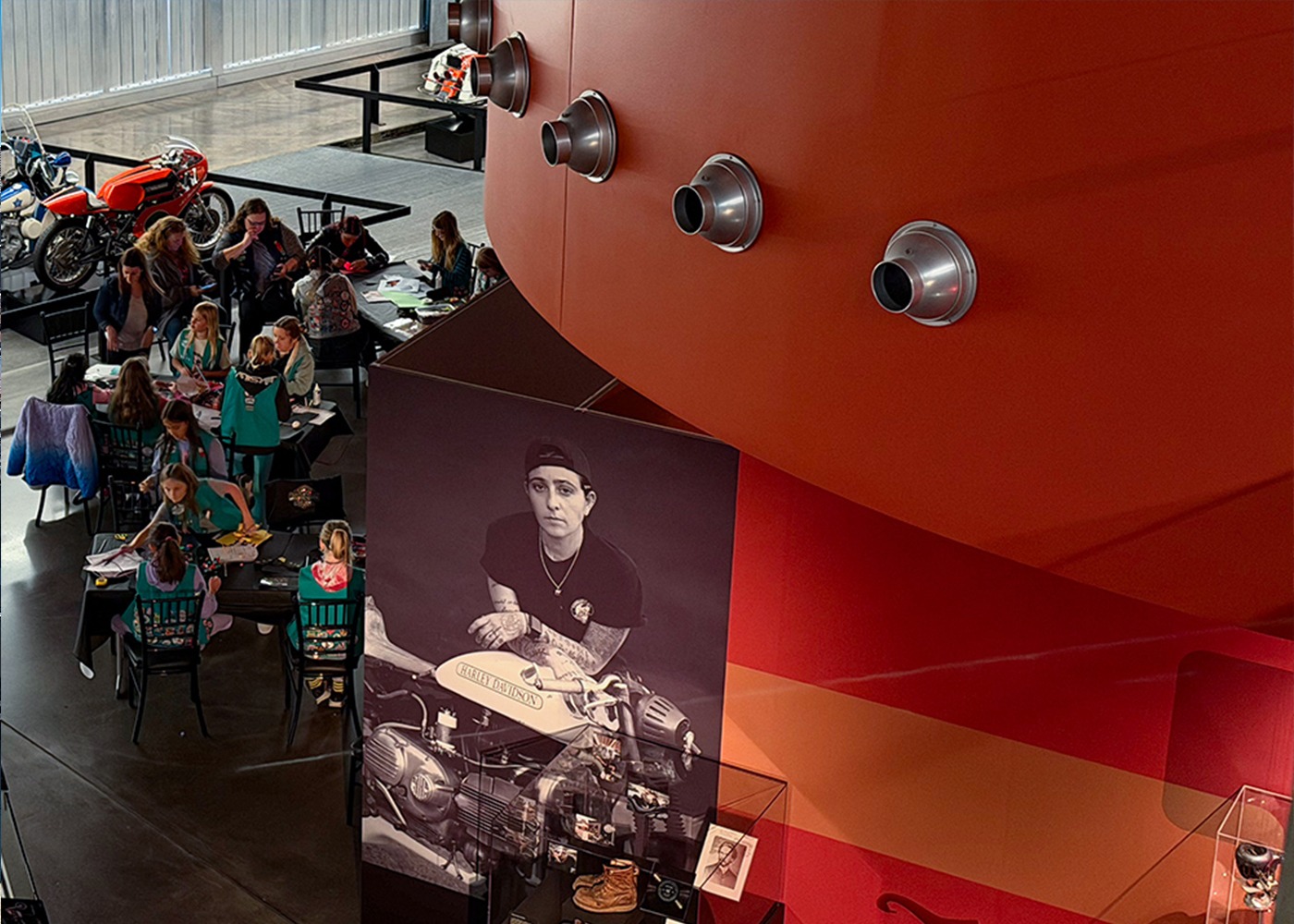 Visitors exploring Harley-Davidson museum exhibit with historic displays