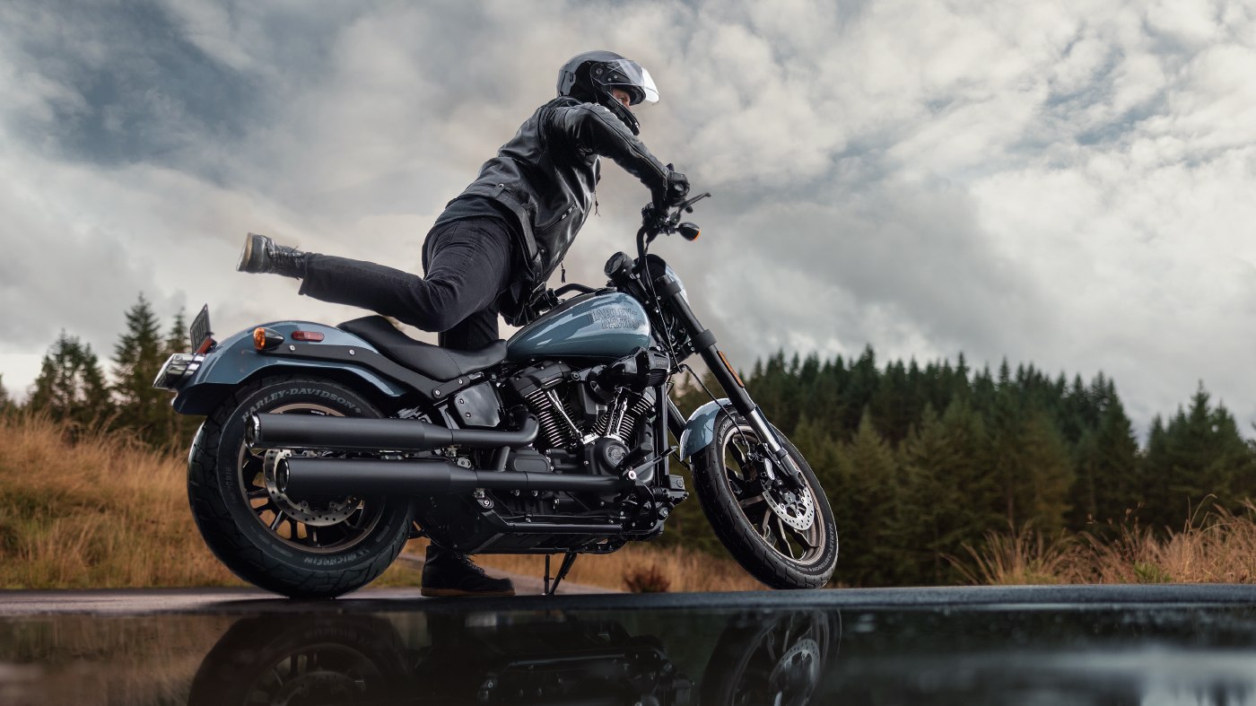 Rider lifts leg over bike to get ready to ride