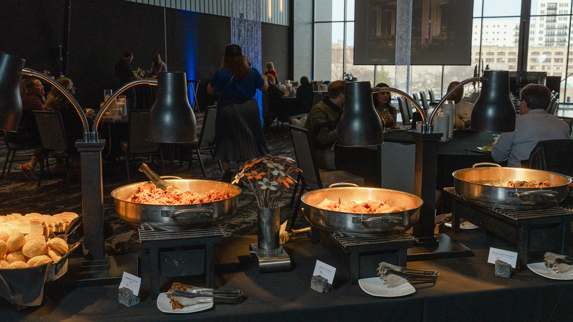 Buffet stations with heated dishes and bread rolls in event hall