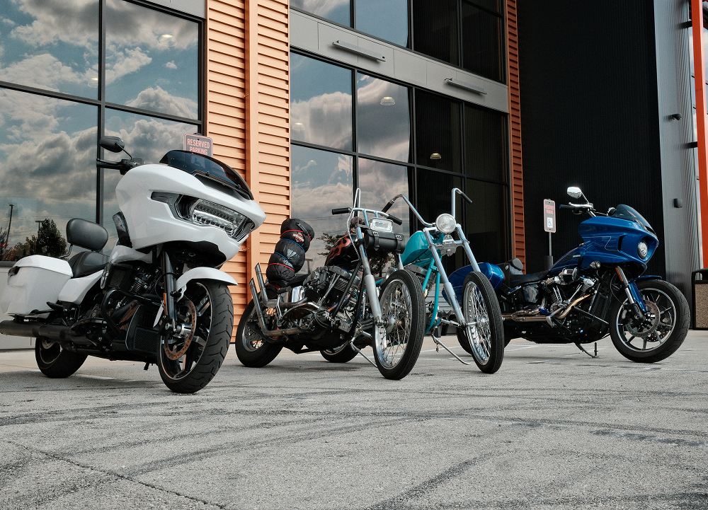 Two custom choppers and two new motorcycles parked in a group in front of Bluegrass Harley-Davidson